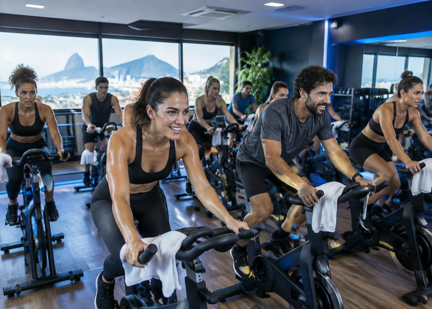 Turma pedalando em uma aula de bike indoor